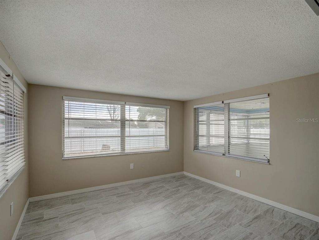 10320 Honeysuckle Lane Port Richey, FL 34668 - Photo 8 of 53 an empty room with wooden floor and windows