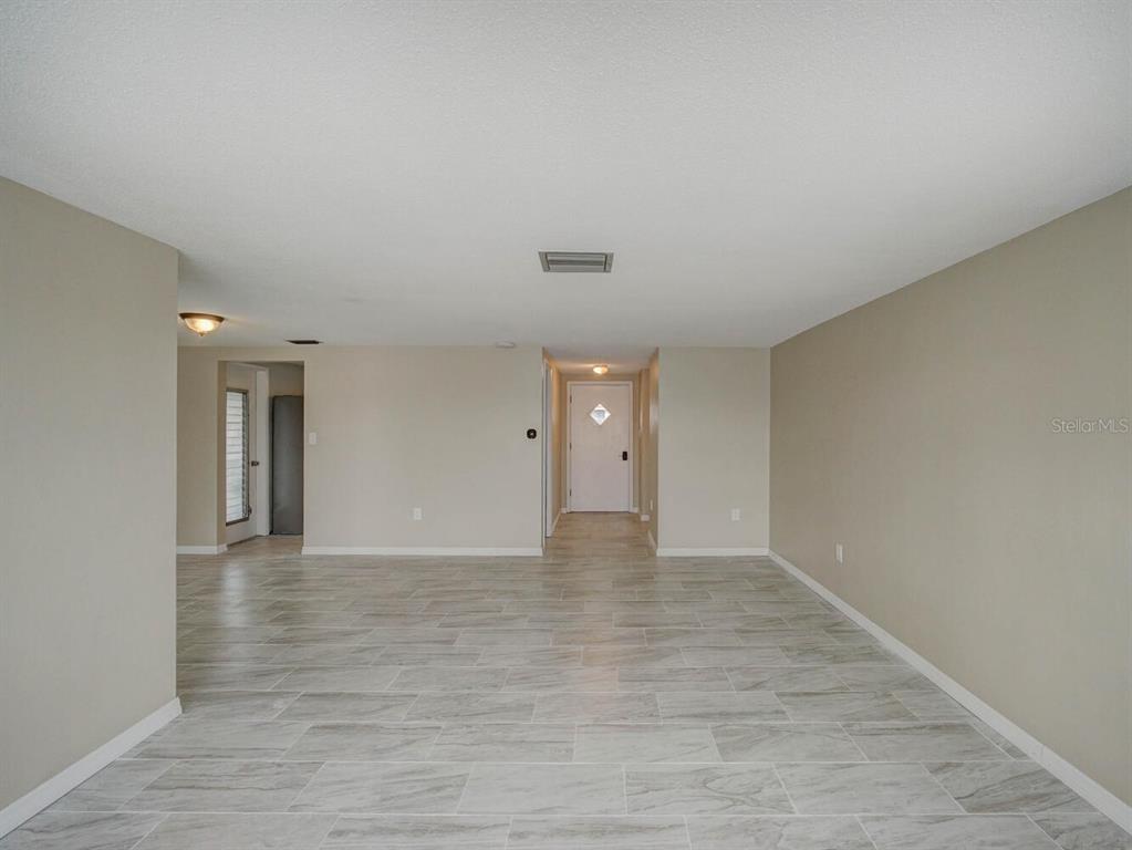 10320 Honeysuckle Lane Port Richey, FL 34668 - Photo 10 of 53 a view of an empty room with wooden floor