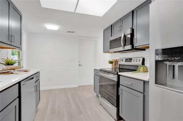 a kitchen with stainless steel appliances a stove microwave and sink