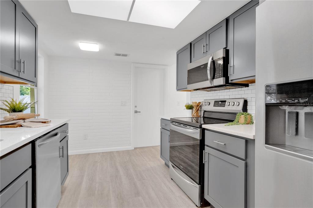 2481 12th Avenue Southwest Largo, FL 33770 - Photo 5 of 21 a kitchen with stainless steel appliances a stove microwave and sink