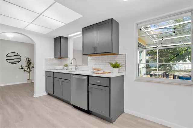 a kitchen with kitchen island granite countertop a sink window and cabinets