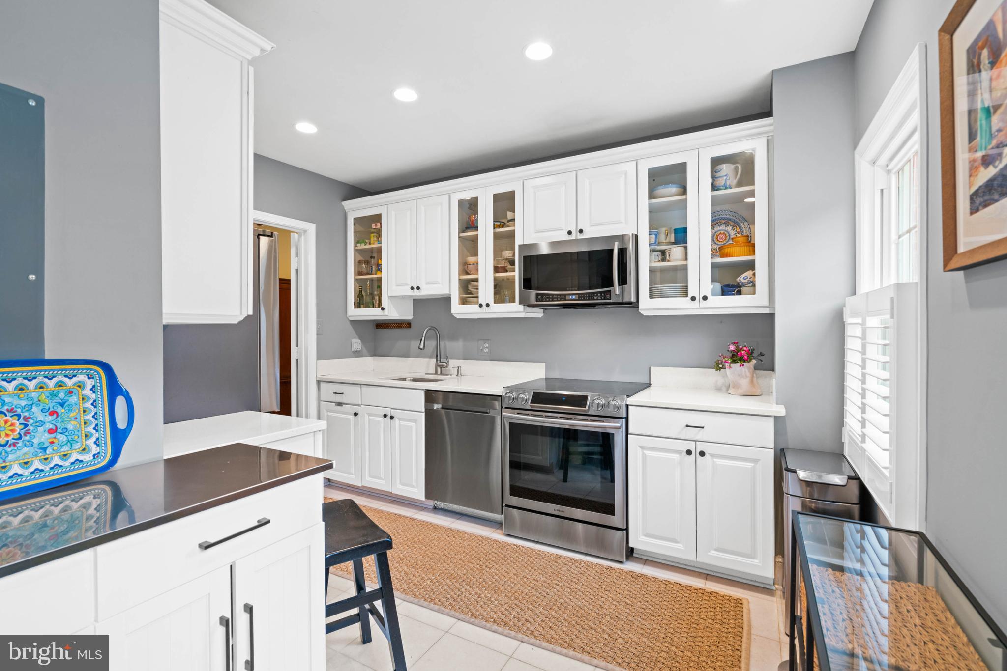 3297 Sutton Place Northwest, Unit B Washington, DC 20016 - Photo 13 of 43 a kitchen with stainless steel appliances granite countertop a stove top oven a sink dishwasher and a refrigerator with wooden floor