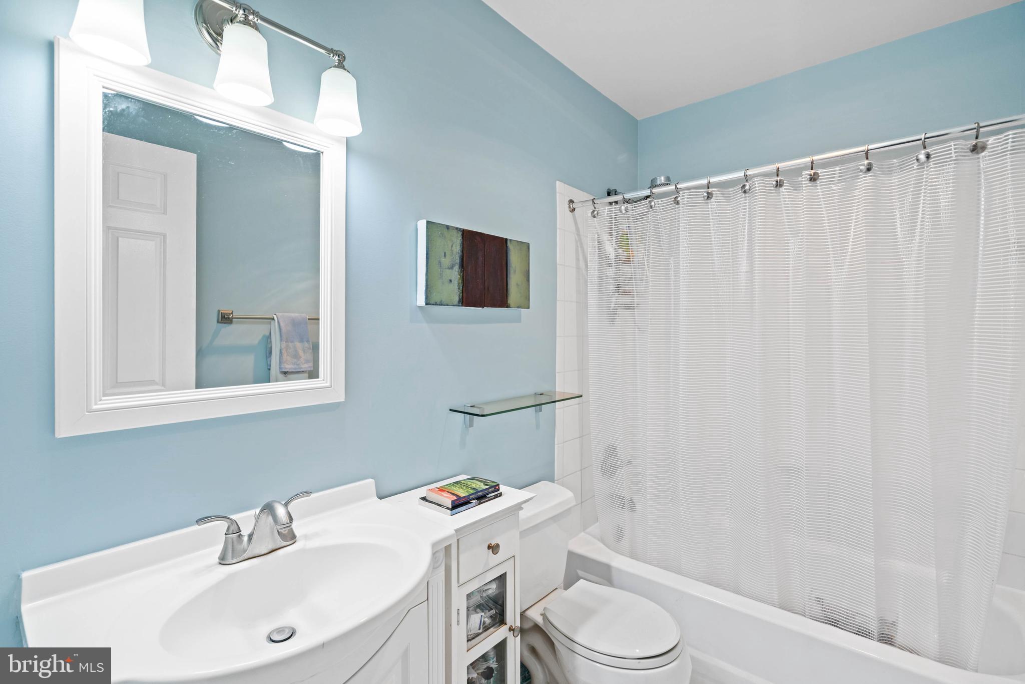 3297 Sutton Place Northwest, Unit B Washington, DC 20016 - Photo 43 of 43 a bathroom with a sink a toilet and shower curtain