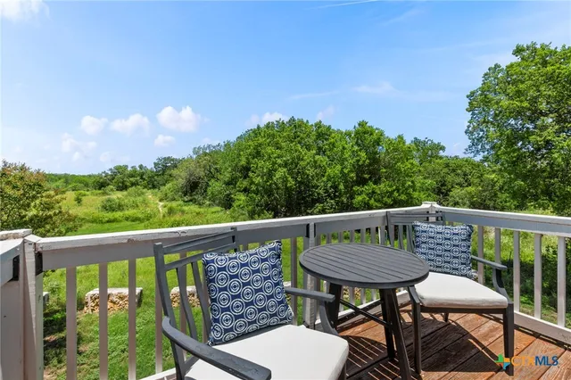 a view of a chair and table on the deck