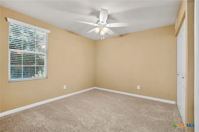 a view of a room with a ceiling fan and a window