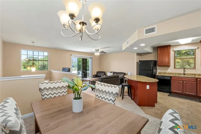 a living room with furniture kitchen view and large windows