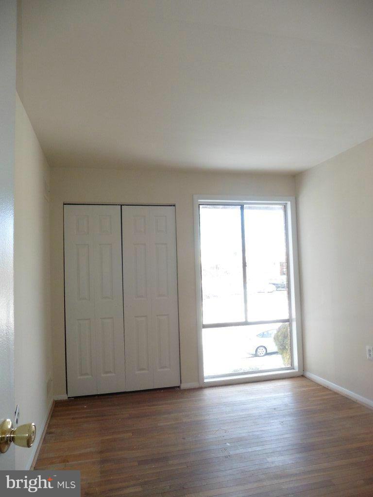 9429 Kilimanjaro Road Columbia, MD 21045 - Photo 9 of 13 a view of an empty room with wooden floor and a window