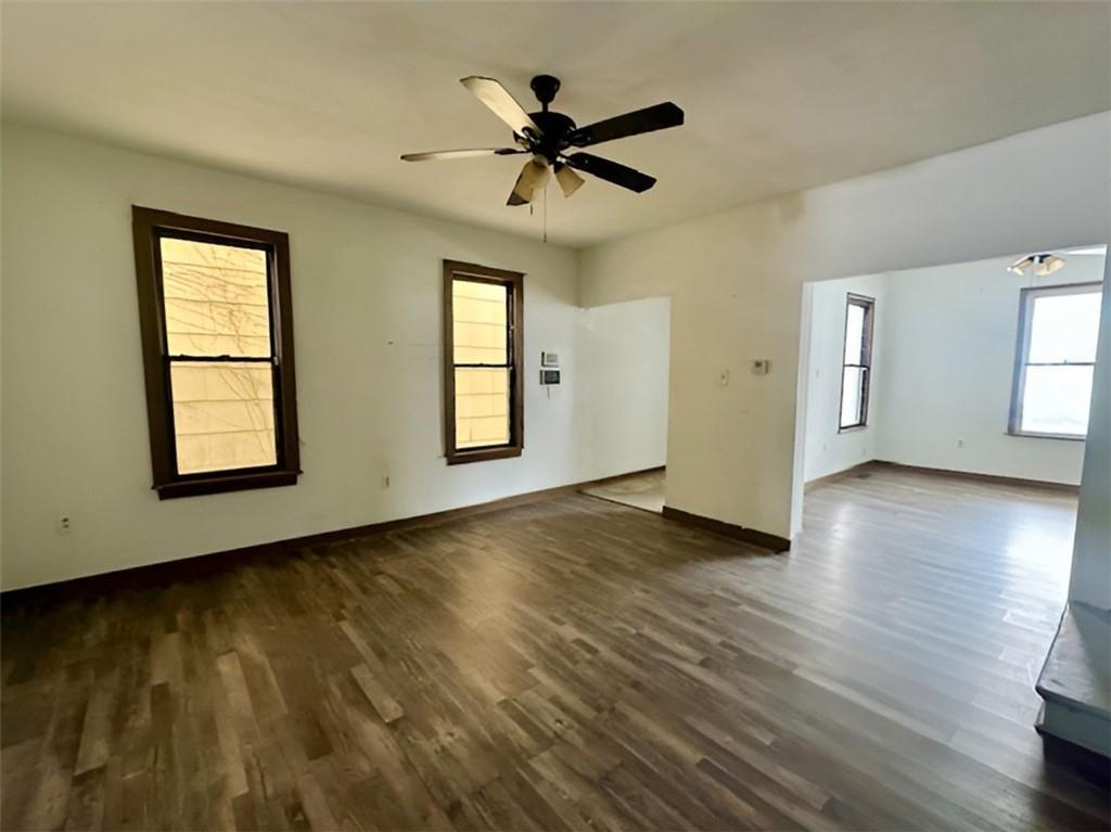 910 9th Avenue Beaver Falls, PA 15010 - Photo 6 of 11 an empty room with wooden floor chandelier fan and windows