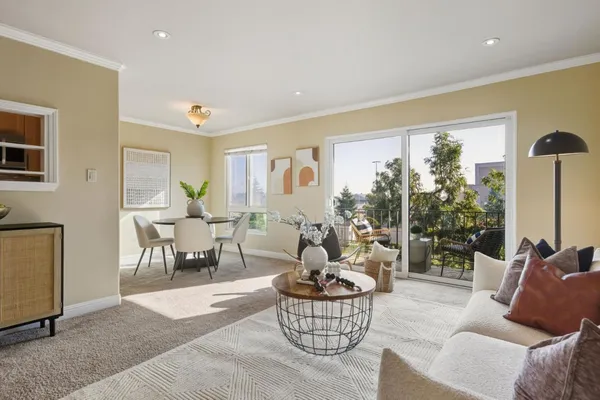 a living room with furniture potted plant and a large window