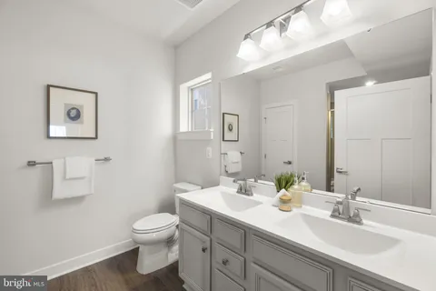a bathroom with a toilet a sink and mirror