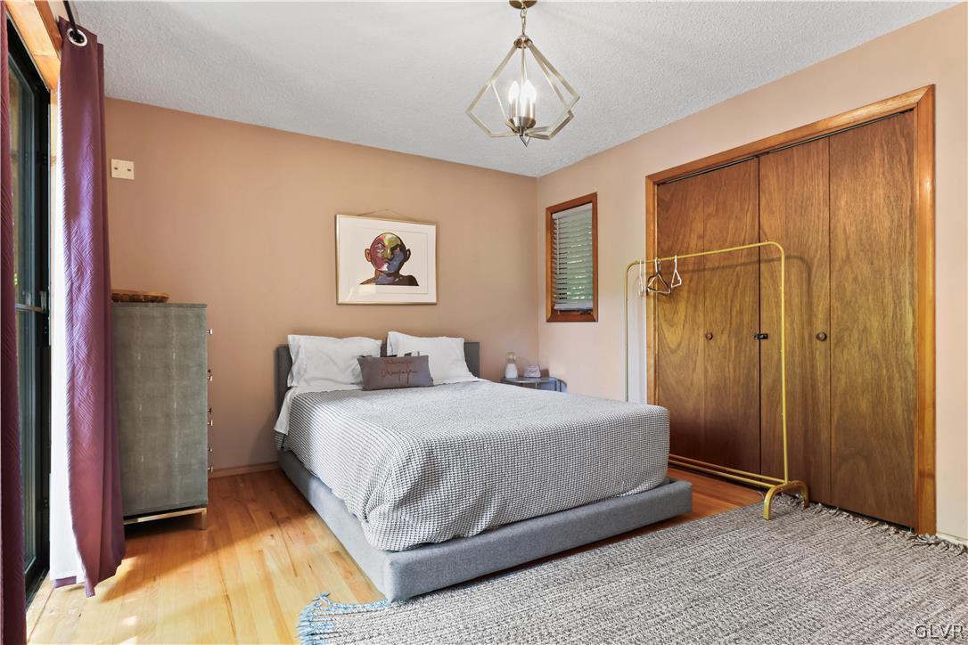 6463 Decker Road Bushkill, PA 18324 - Photo 30 of 50 a bedroom with a large bed and a chandelier