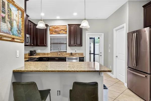 a kitchen with stainless steel appliances granite countertop a sink refrigerator and microwave