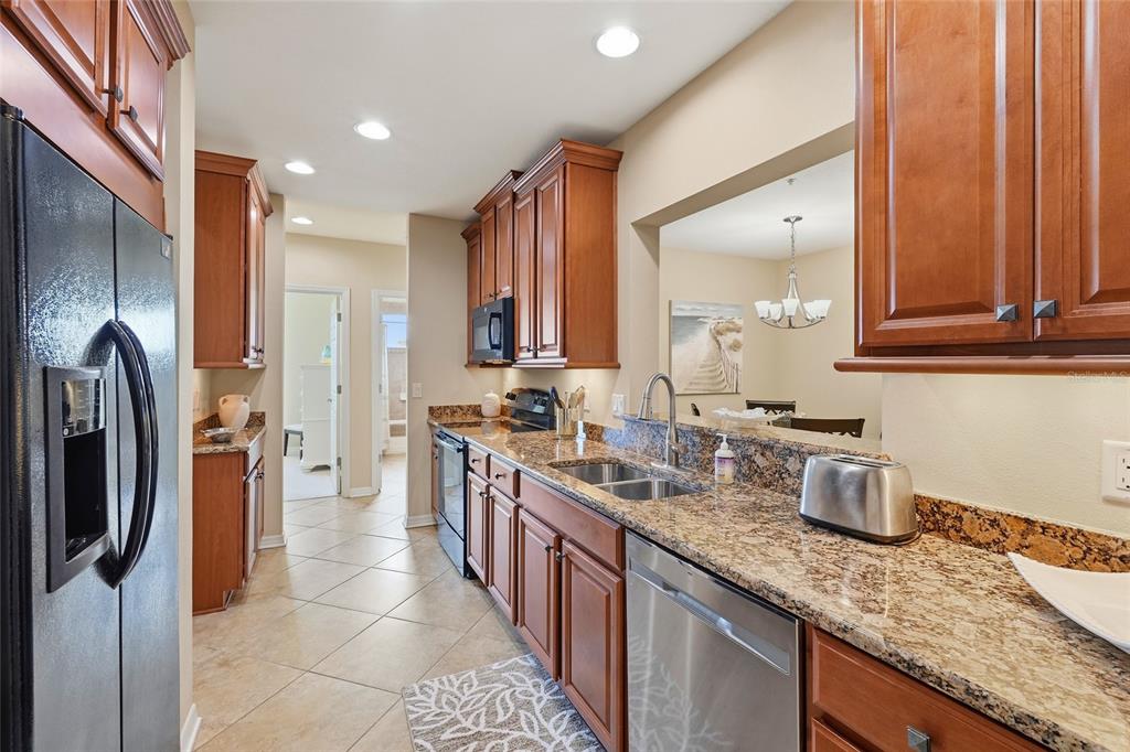 7321 Skybird Road, Unit 397 Bradenton, FL 34209 - Photo 10 of 35 a kitchen with stainless steel appliances granite countertop a sink stove and refrigerator