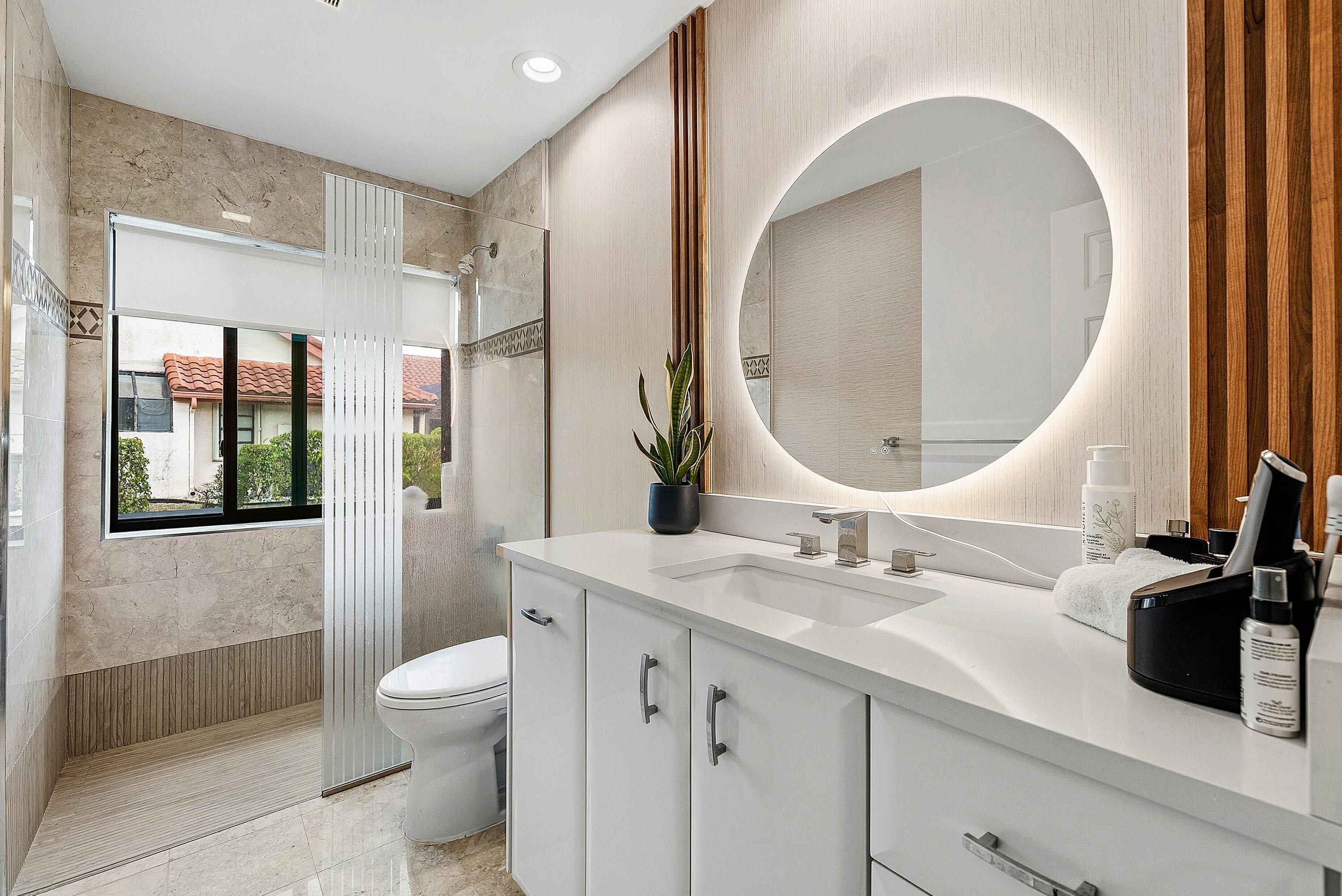10710 Boca Woods Lane Boca Raton, FL 33428 - Photo 15 of 44 a bathroom with a sink a toilet and a mirror