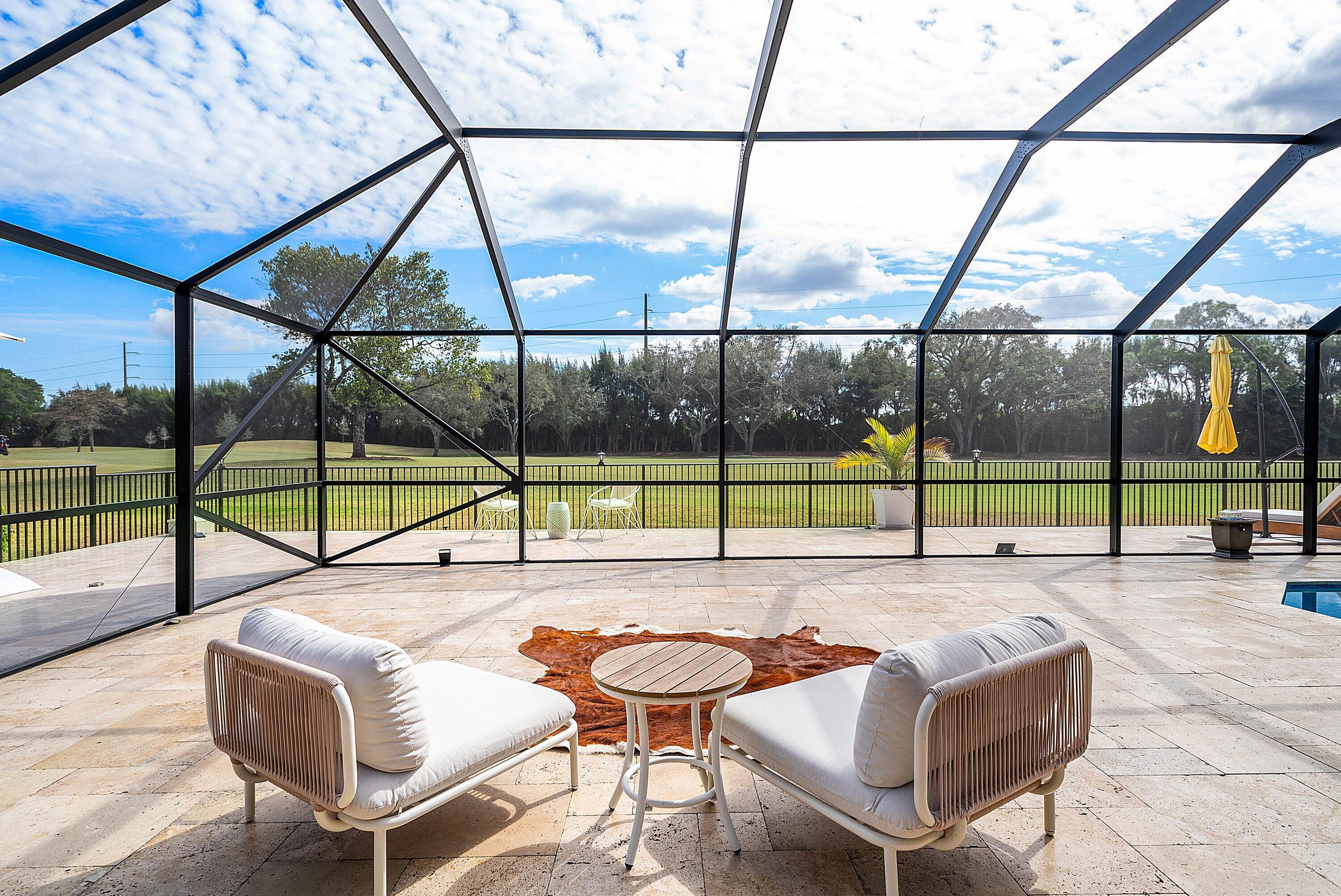 10710 Boca Woods Lane Boca Raton, FL 33428 - Photo 18 of 44 a swimming pool with chairs and city view