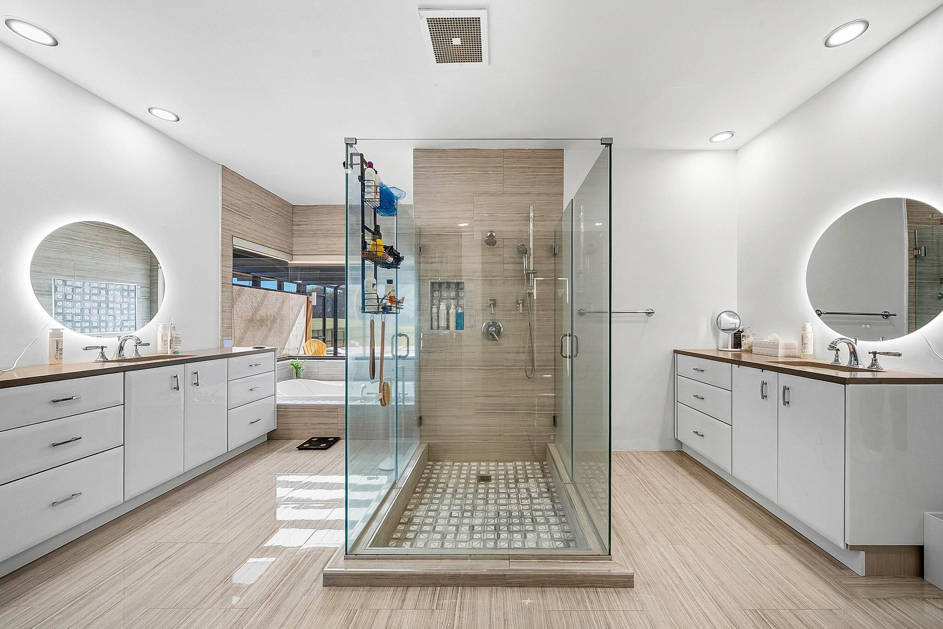 10710 Boca Woods Lane Boca Raton, FL 33428 - Photo 8 of 44 a bathroom with a double vanity sink a toilet a mirror and shower