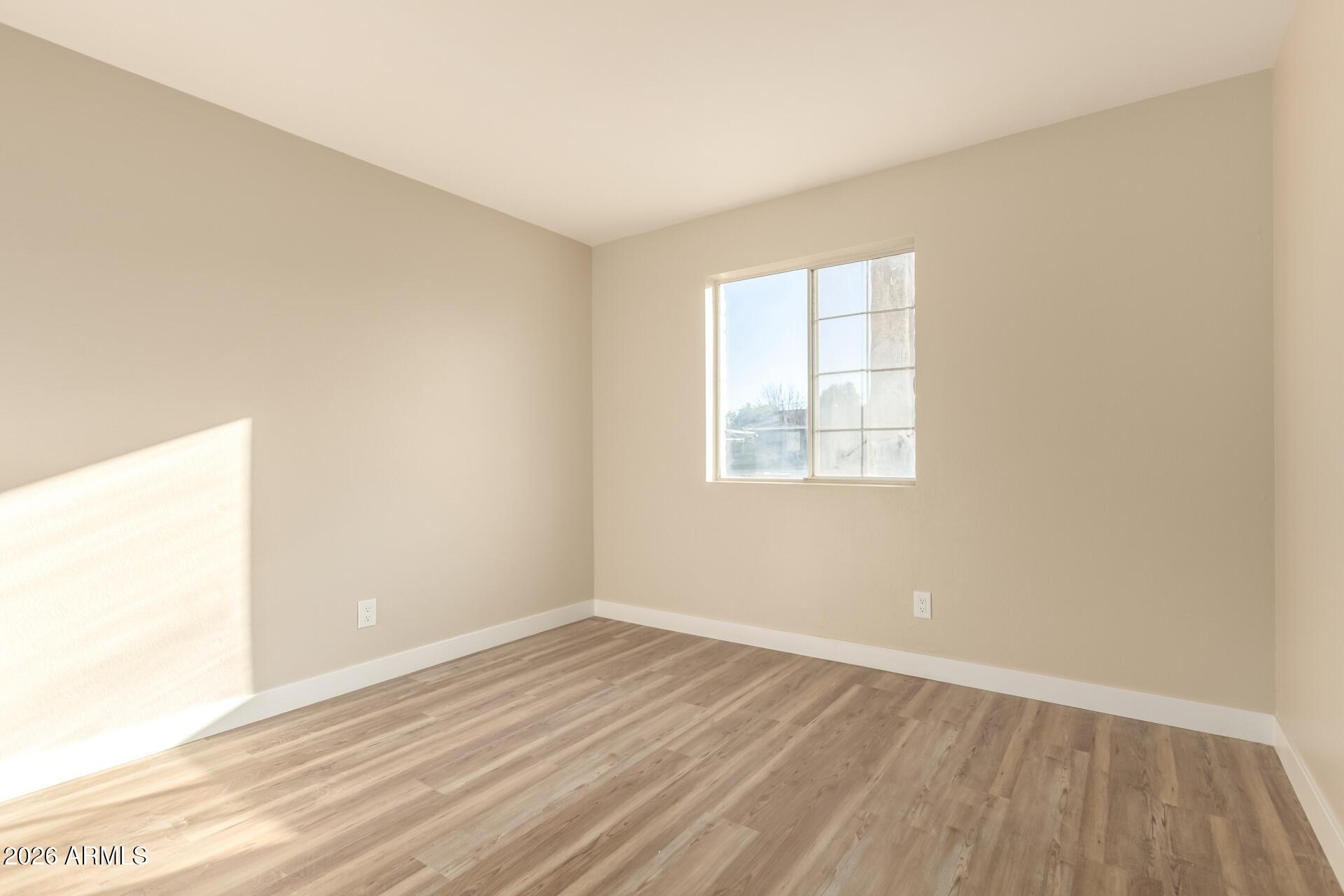 2834 East Shangri-La Road Phoenix, AZ 85028 - Photo 21 of 33 an empty room with wooden floor and windows