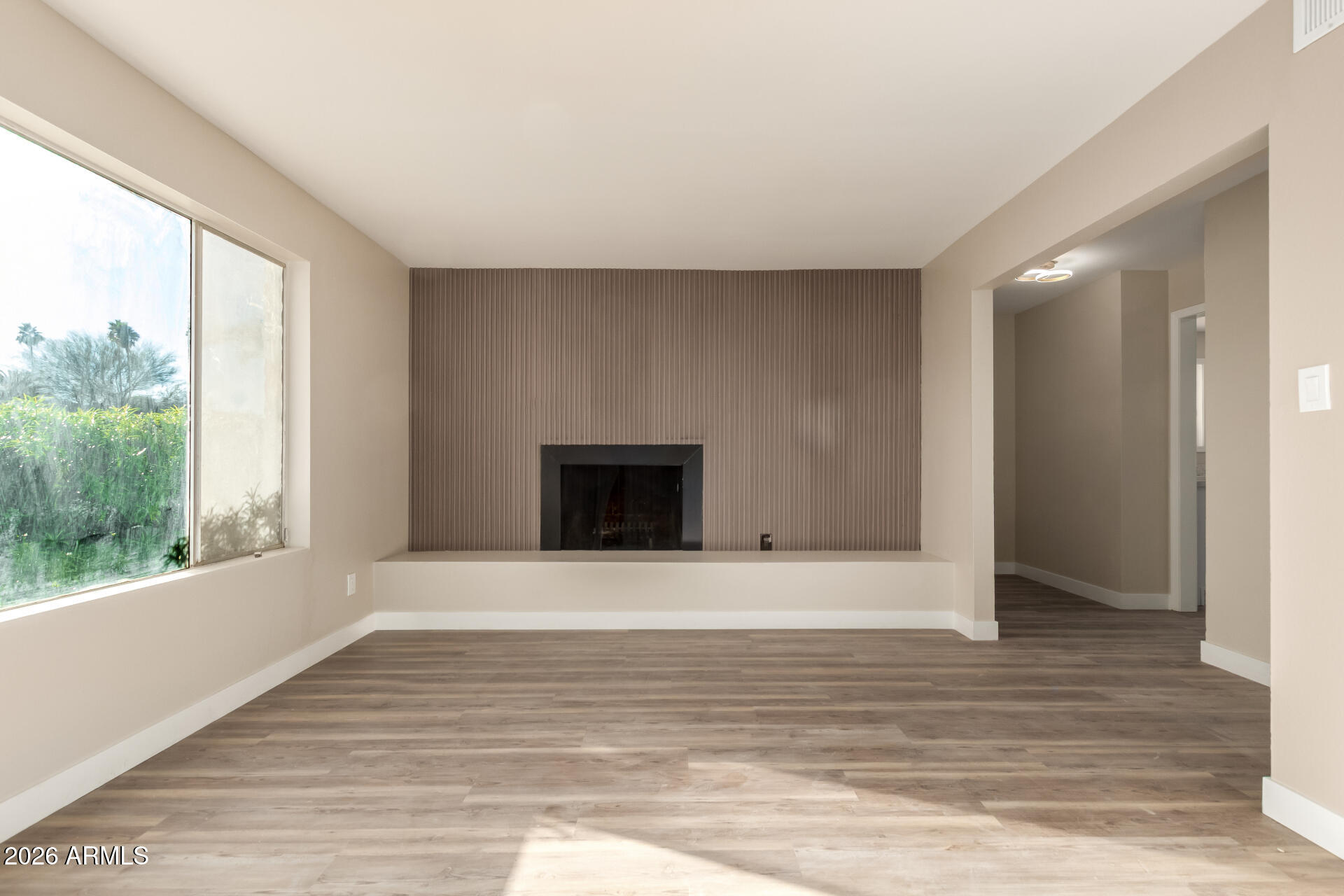 2834 East Shangri-La Road Phoenix, AZ 85028 - Photo 8 of 33 a view of an empty room with wooden floor and a window