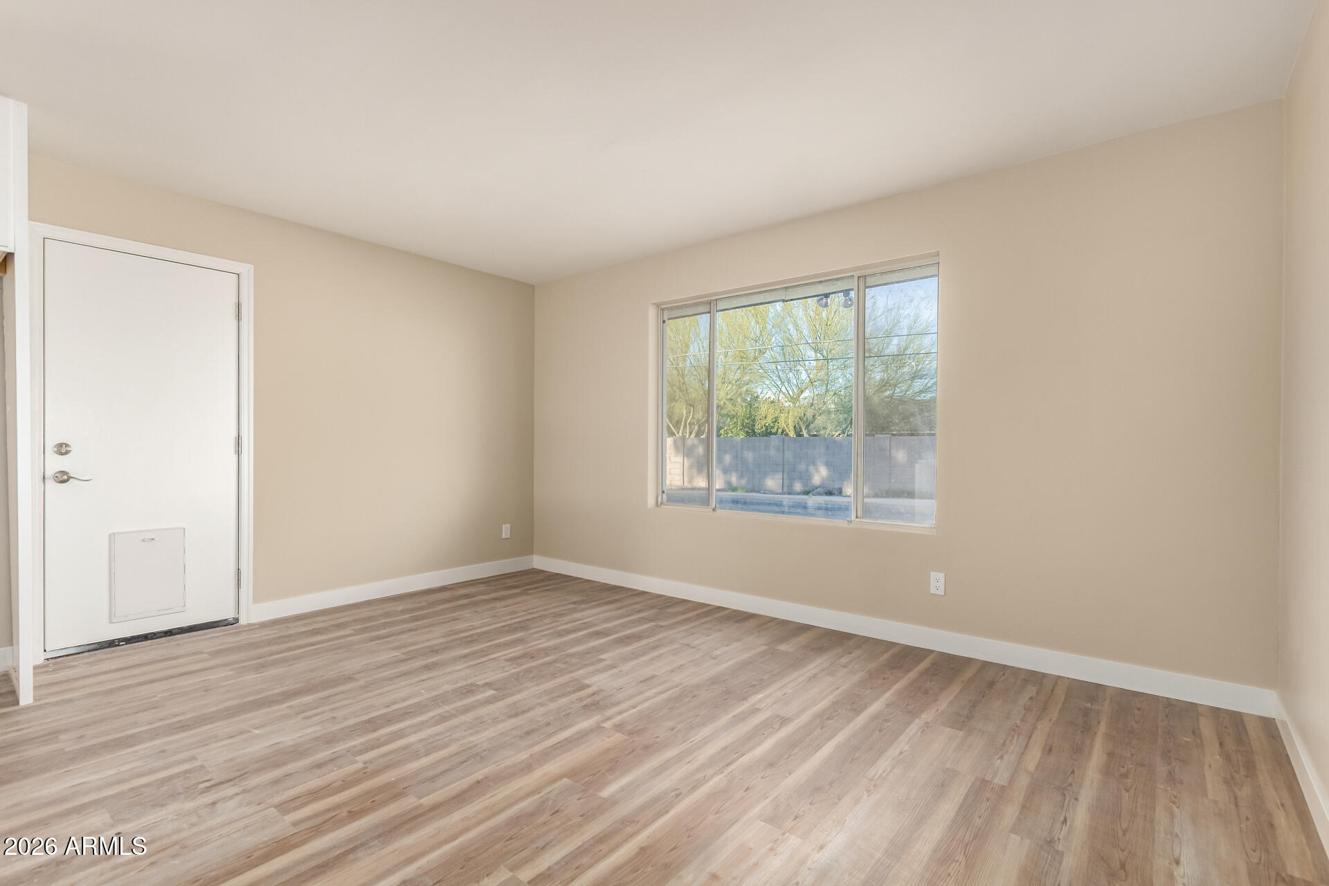 2834 East Shangri-La Road Phoenix, AZ 85028 - Photo 10 of 33 an empty room with wooden floor and windows