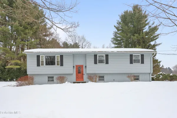 a front view of a house with a yard covered in snow
