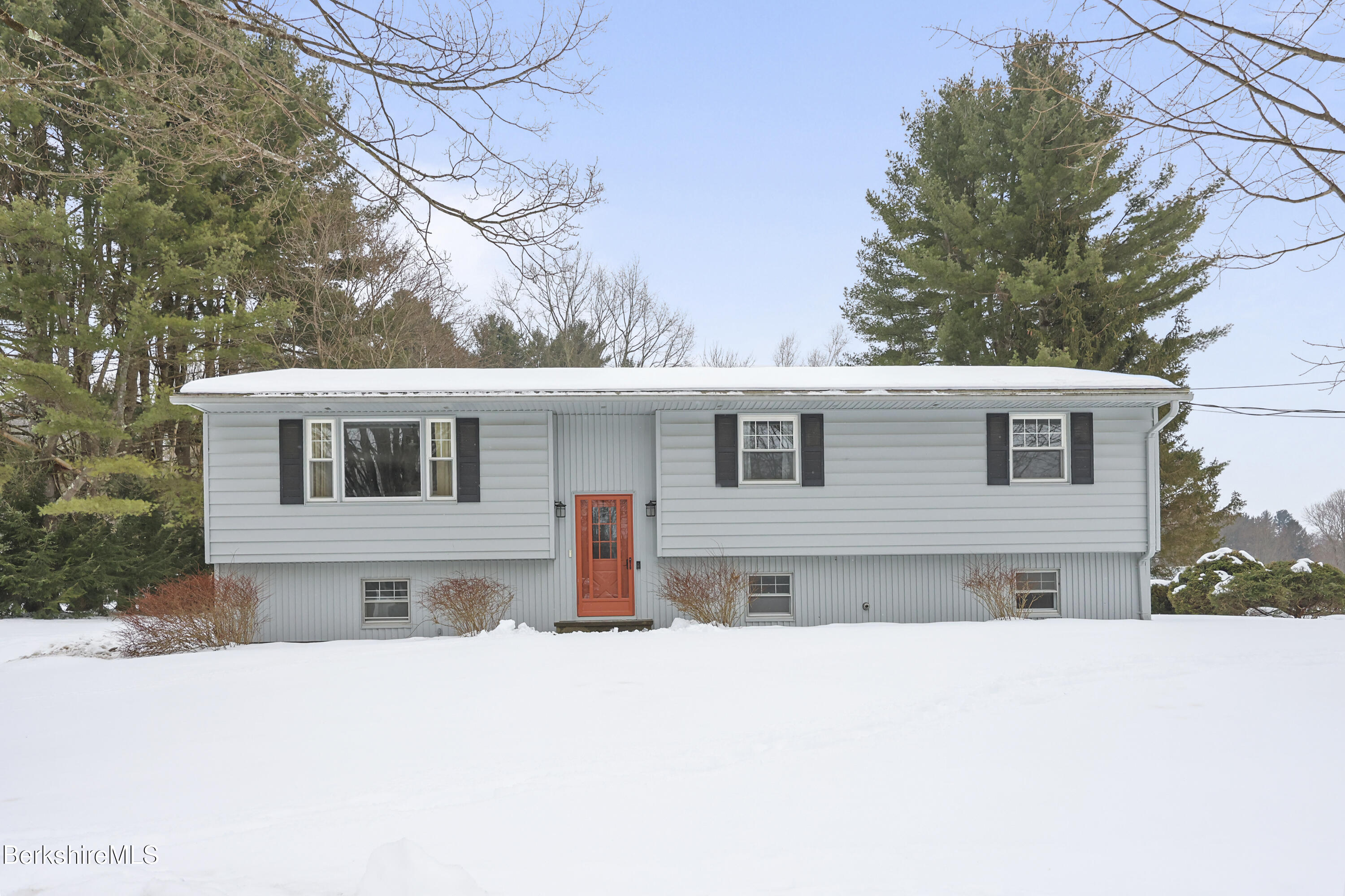 a front view of a house with a yard covered in snow