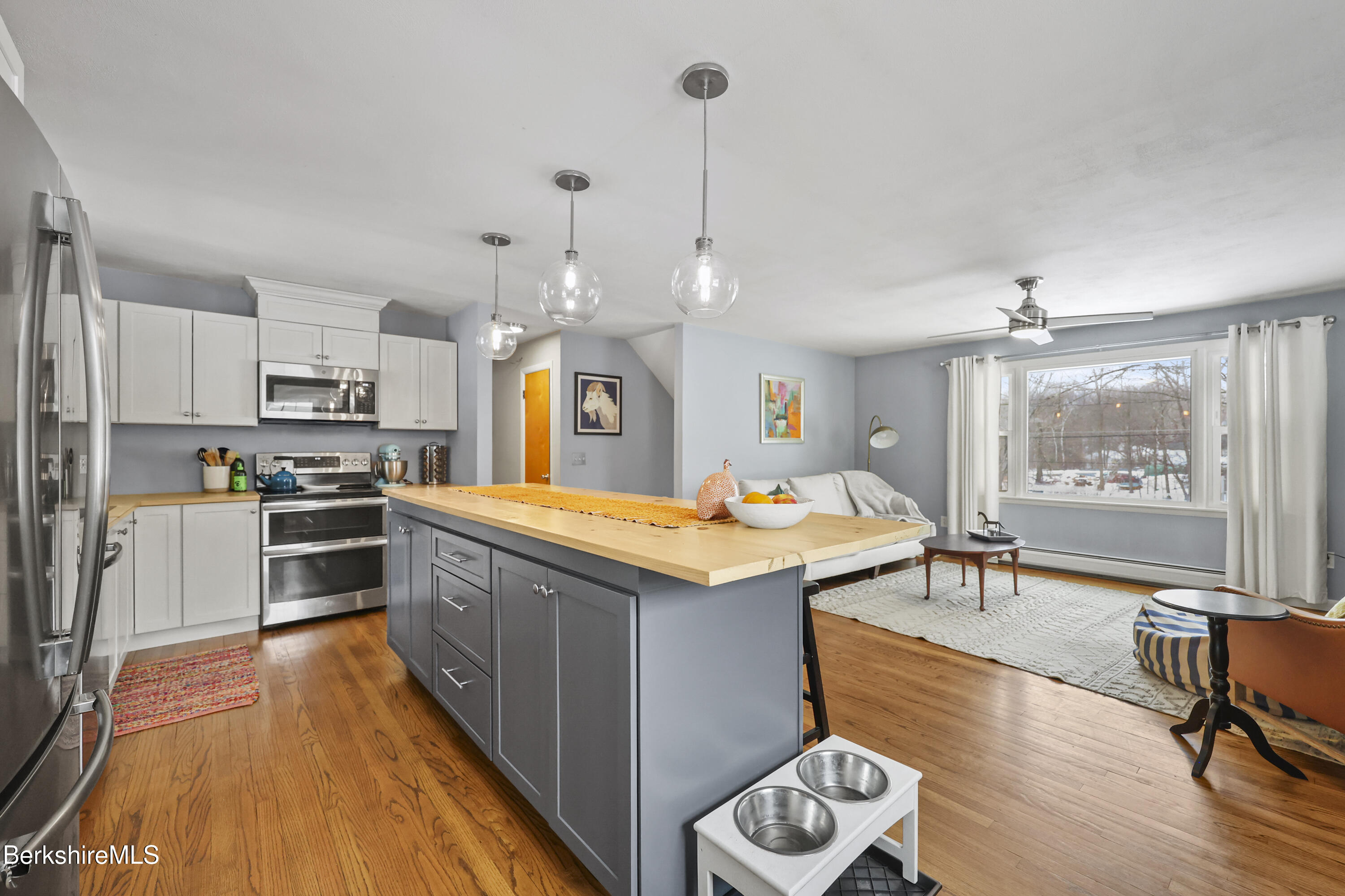 184 Washington Mountain Road Lee, MA 01238 - Photo 15 of 42 a kitchen with granite countertop a stove a sink a refrigerator and a dining table with wooden floor