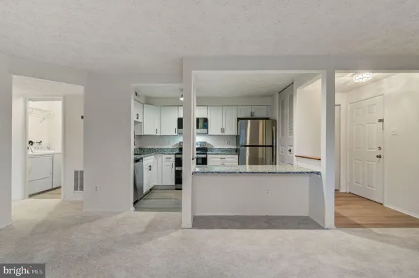 a view of kitchen with stainless steel appliances refrigerator sink and cabinets