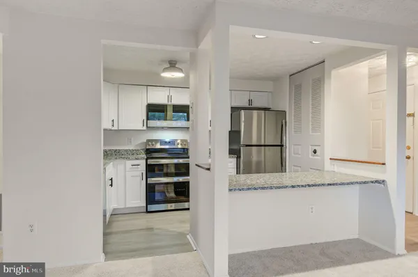 a kitchen with stainless steel appliances granite countertop a refrigerator and a stove top oven