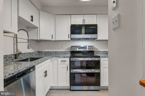 a kitchen with stainless steel appliances granite countertop a stove microwave and oven