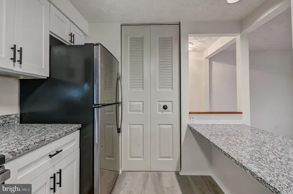a kitchen with stainless steel appliances granite countertop a refrigerator and a sink
