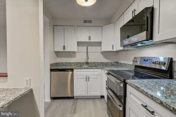 a kitchen with stainless steel appliances granite countertop a sink and a stove top oven