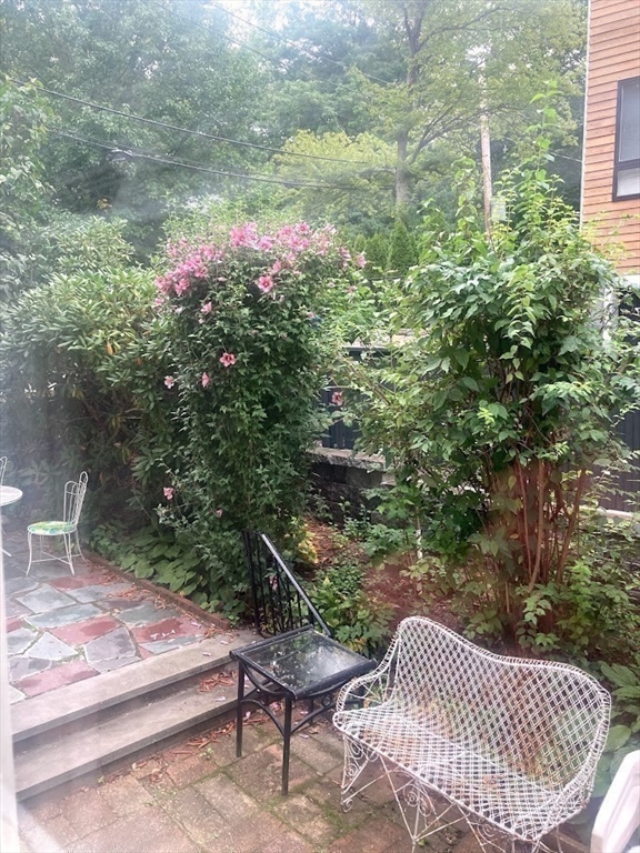 28 Beaconsfield Road, Unit 1 Brookline, MA 02445 - Photo 20 of 21 a backyard of a house with table and chairs and potted plants