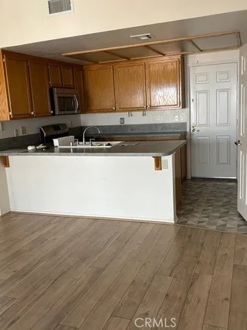 a kitchen with stainless steel appliances granite countertop a stove a sink and a microwave