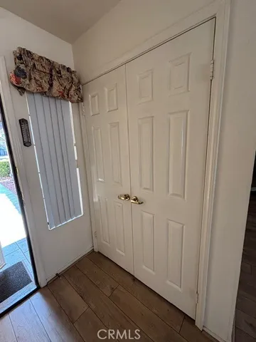 a view of a hallway with wooden floor and closet