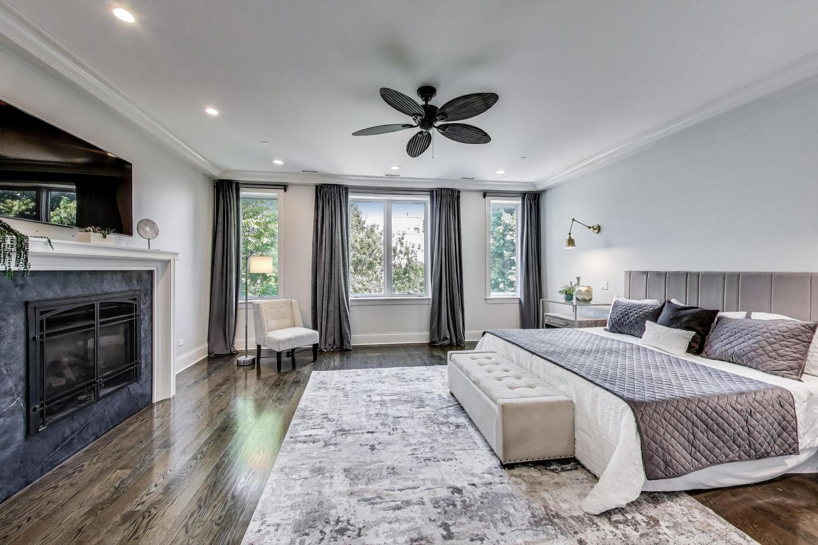 1758 West Surf Street Chicago, IL 60657 - Photo 24 of 51 a spacious bedroom with a large bed and a fireplace