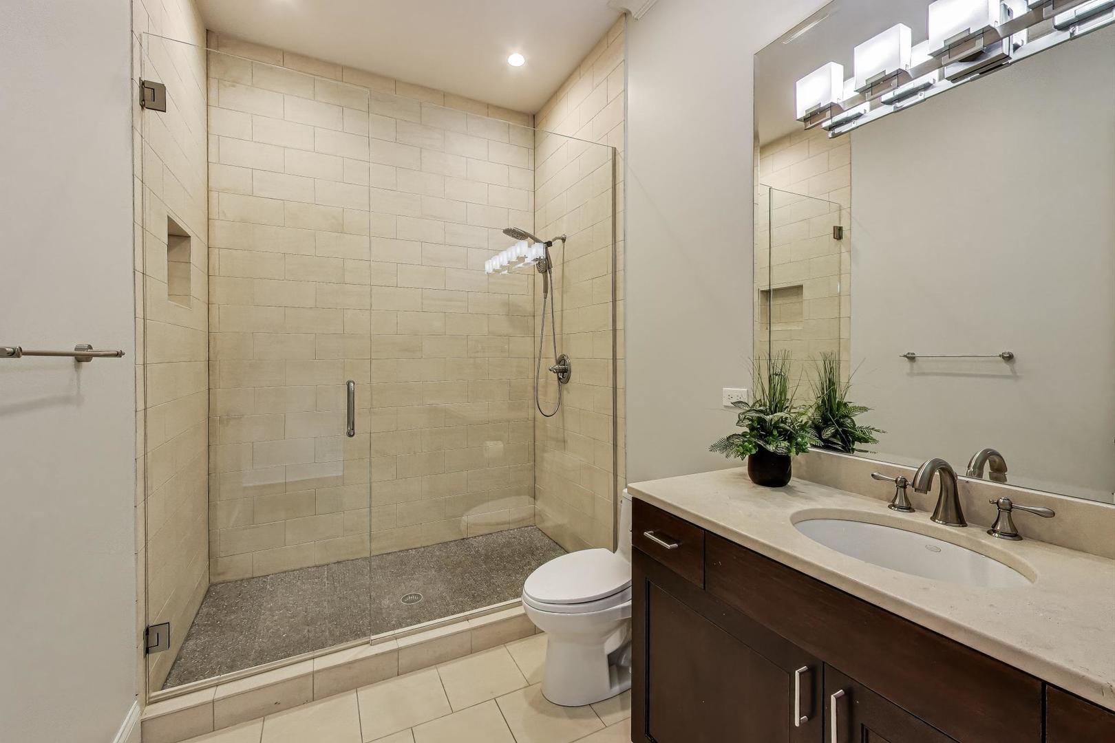 1758 West Surf Street Chicago, IL 60657 - Photo 43 of 51 a bathroom with a granite countertop sink a toilet and shower