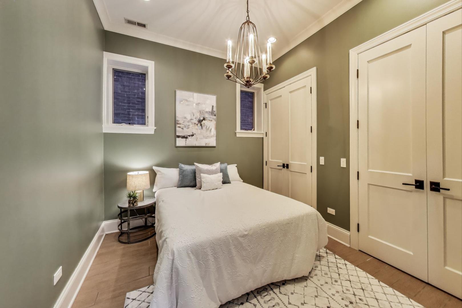 1758 West Surf Street Chicago, IL 60657 - Photo 46 of 51 a bedroom with a bed and a chandelier
