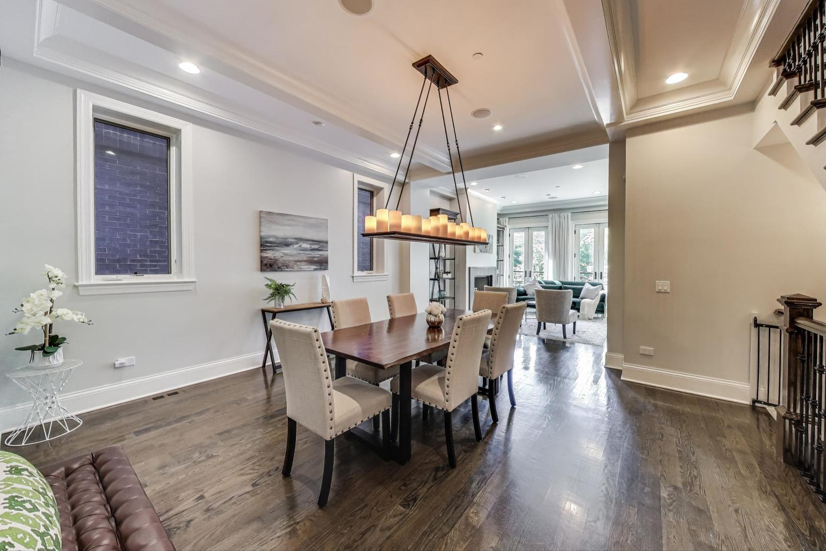 1758 West Surf Street Chicago, IL 60657 - Photo 8 of 51 a dining room with wooden floor a chandelier a wooden table and chairs