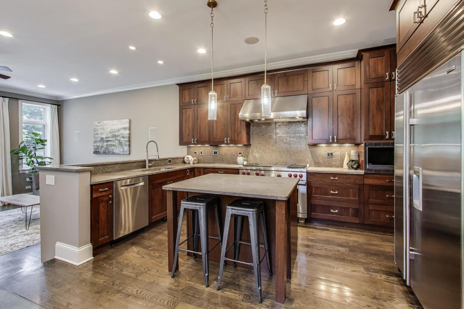 1758 West Surf Street Chicago, IL 60657 - Photo 10 of 51 a kitchen with kitchen island granite countertop a sink and a refrigerator