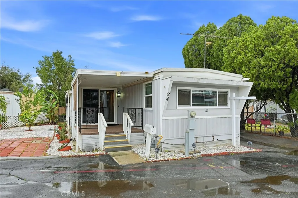 8787 Locust, Unit 24 Fontana, CA 92335 - Photo 1 of 27 a view of a white house with large windows and plants