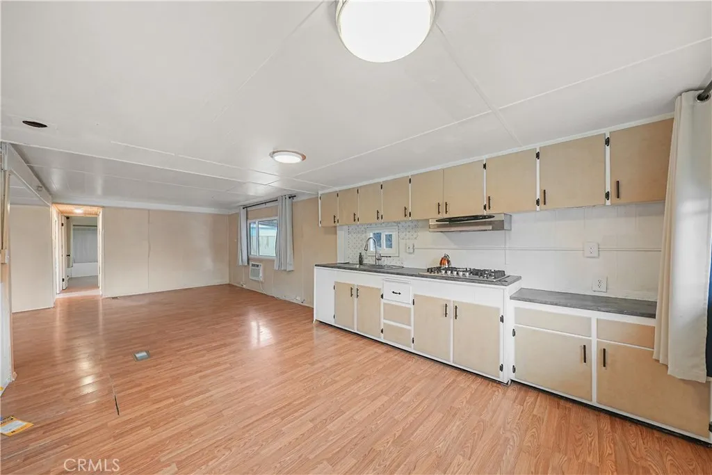 8787 Locust, Unit 24 Fontana, CA 92335 - Photo 11 of 27 a kitchen with stainless steel appliances granite countertop a stove top oven a sink dishwasher and white cabinets with wooden floor