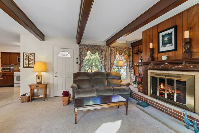 a dining room with stainless steel appliances kitchen island granite countertop a table chairs and a refrigerator
