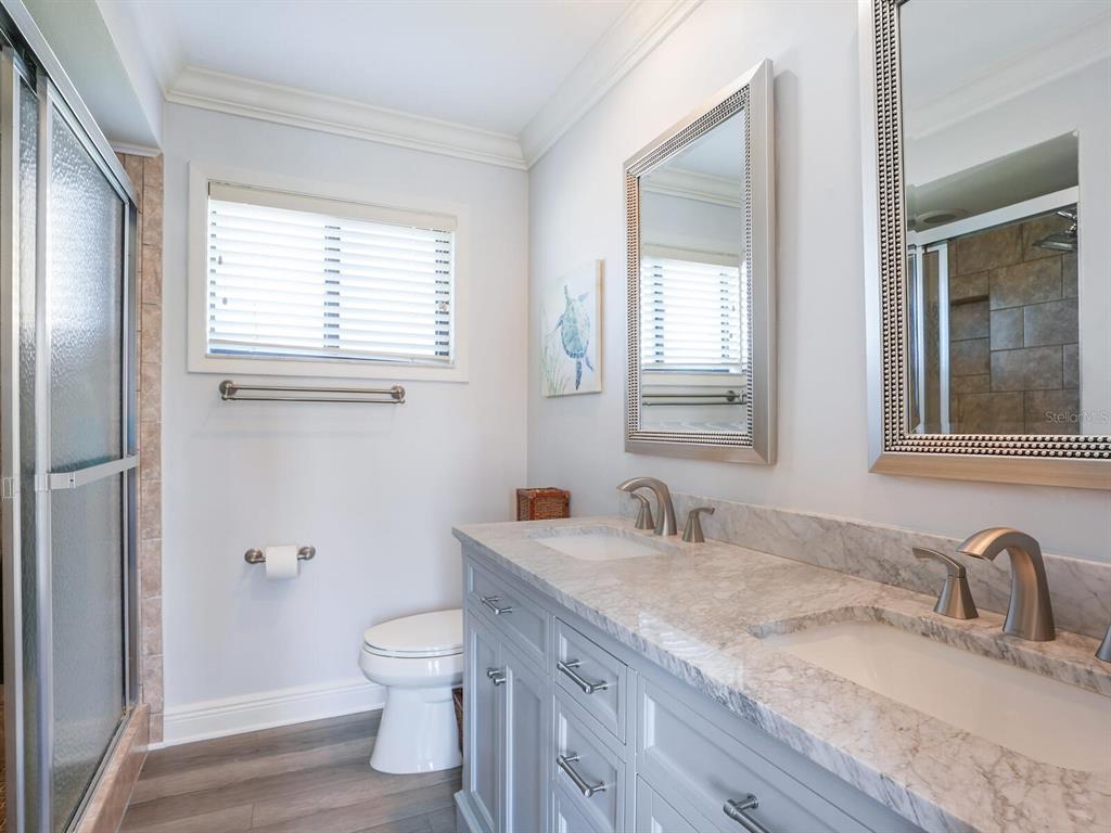 3240 Casey Key Road Nokomis, FL 34275 - Photo 42 of 51 a bathroom with a granite countertop sink a toilet and a window