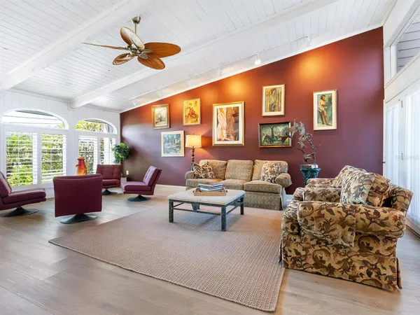 a living room with furniture ceiling fan and a window