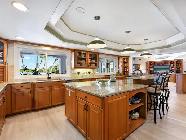a kitchen with stainless steel appliances granite countertop a sink a stove and a wooden floors