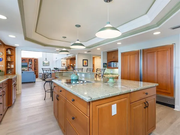 a kitchen with stainless steel appliances granite countertop a sink a stove and a wooden floors