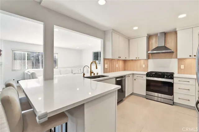 a kitchen with stainless steel appliances granite countertop a refrigerator sink and stove