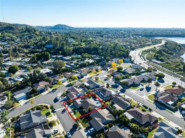 an aerial view of a city with lots of residential buildings and ocean view in back