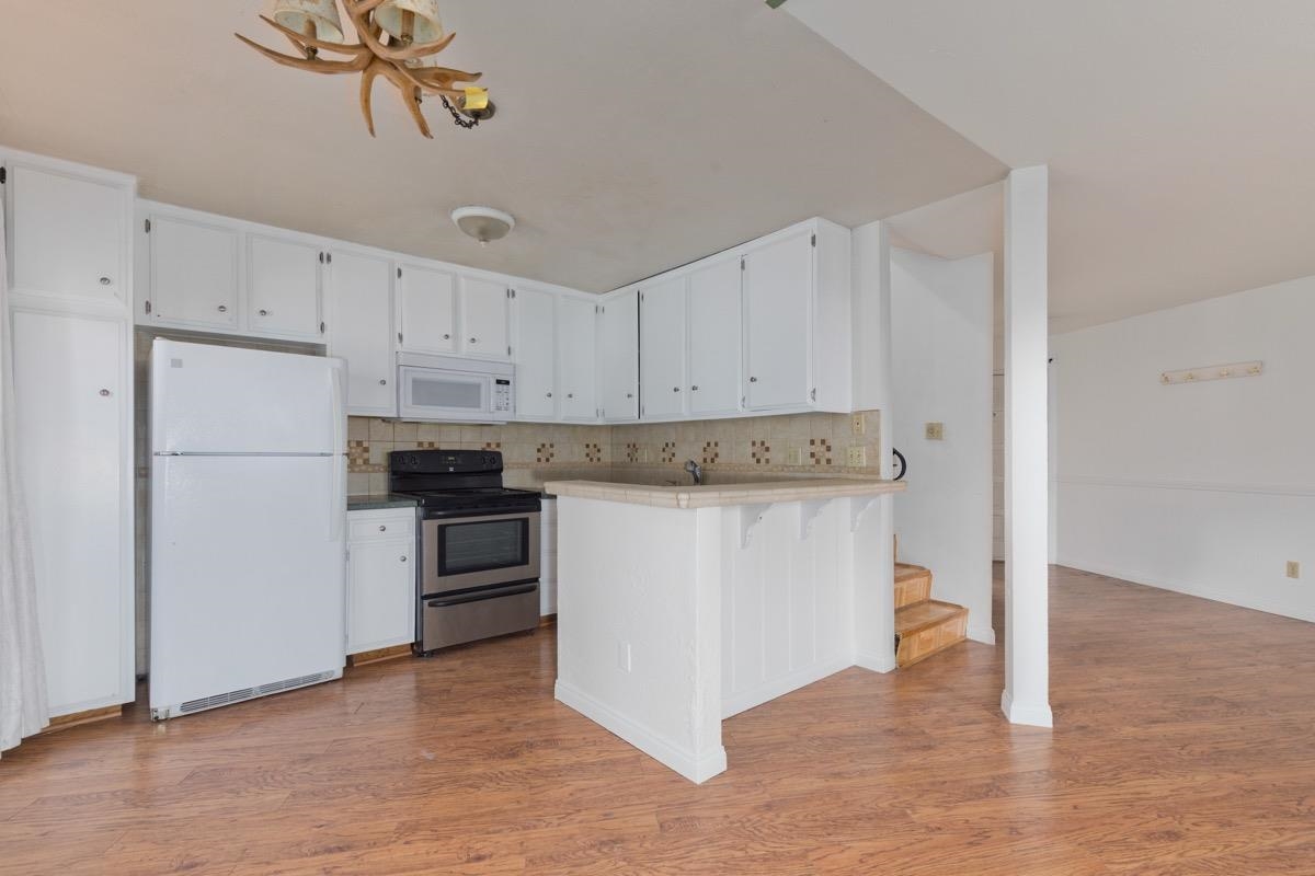 286 Old Mammoth Road, Unit 59 Mammoth Lakes, CA 93546 - Photo 6 of 31 a kitchen with a refrigerator and white cabinets