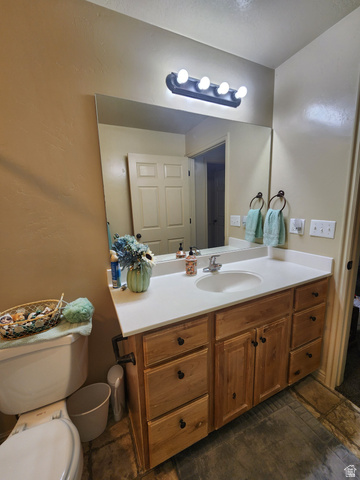 2525 West 450 South, Unit 8 Springville, UT 84663 - Photo 14 of 22 Bathroom vanity featuring a single basin, light-toned countertop, and natural wood-finish cabinetry with multiple drawers and double doors